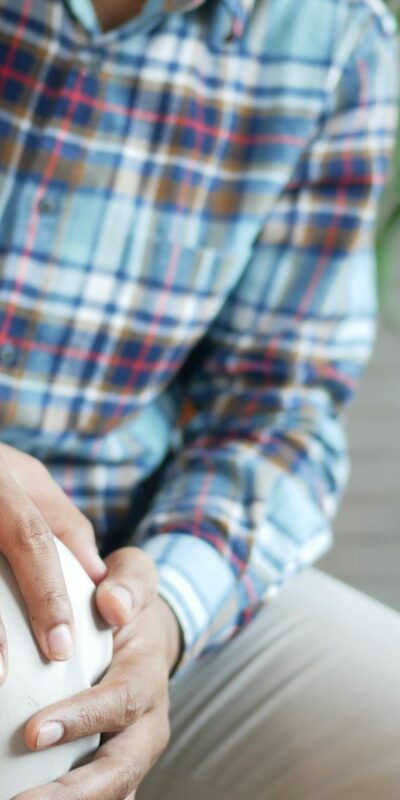 A Person in Plaid Long Sleeves Holding His Knee